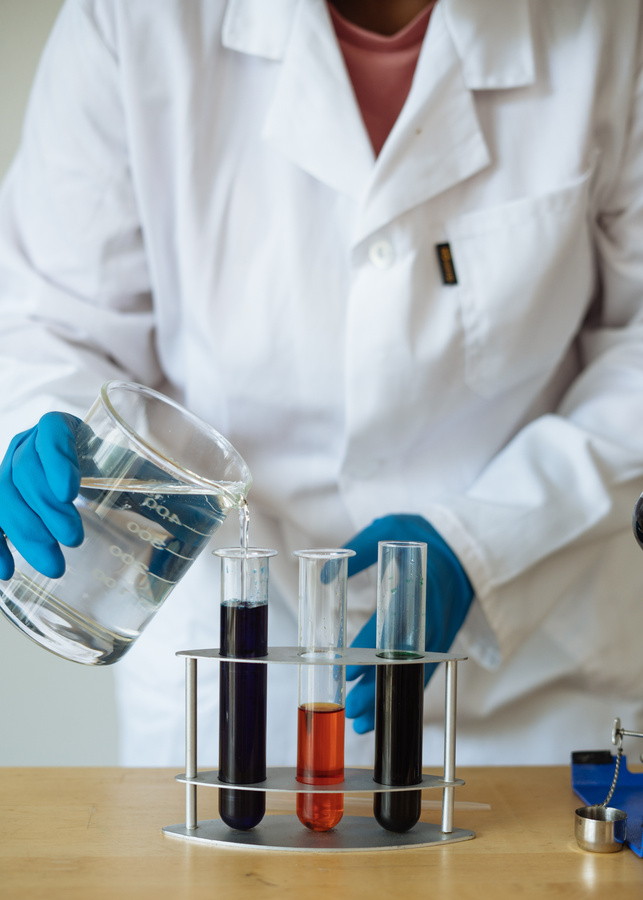 Unrecognizable scientist examining chemical reagents in research center